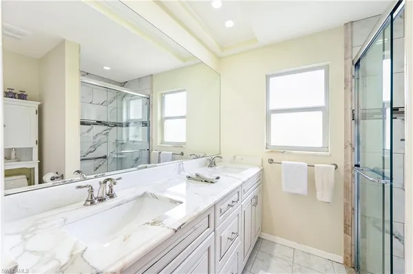 a bathroom with double vanity sinks and a mirror