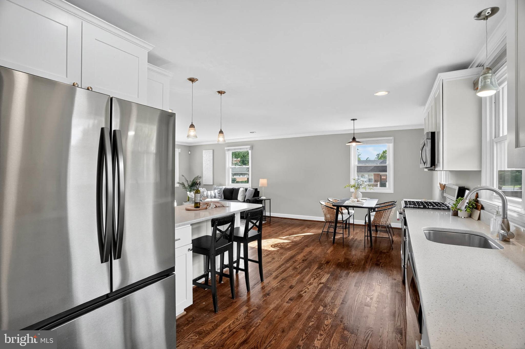 1920 Drummond Road Catonsville, MD 21228 - Photo 13 of 45 a kitchen with stainless steel appliances a refrigerator a stove a dining table and chairs with wooden floor