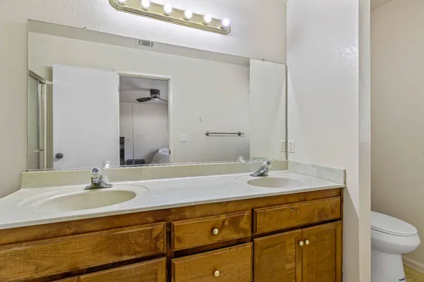 a bathroom with a granite countertop sink a toilet and a mirror