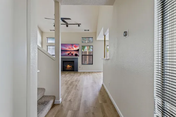 a view of a hallway with wooden floor and staircase