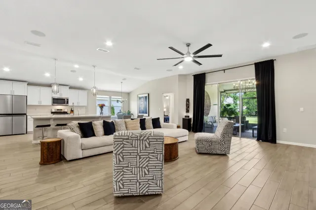 a dining room with wooden floor a chandelier a wooden table and chairs