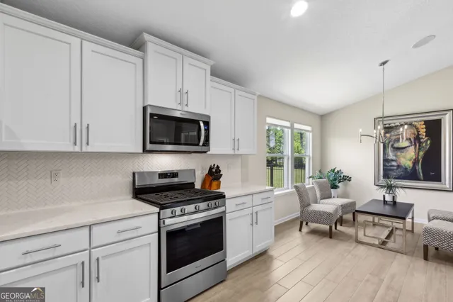 a kitchen with sink and white cabinets with wooden floor