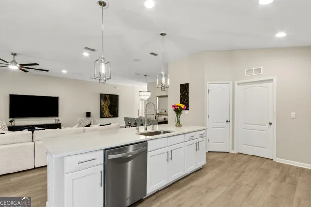 a kitchen with sink refrigerator dining table and chairs