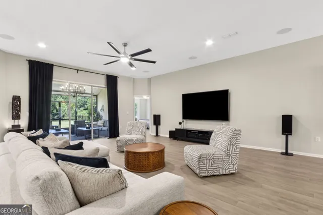 a dining room with wooden floor a chandelier a wooden table and chairs