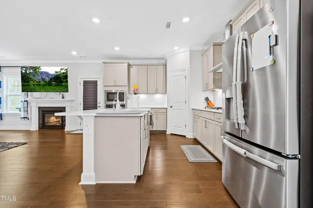 a kitchen with kitchen island a counter top space a sink stainless steel appliances and cabinets