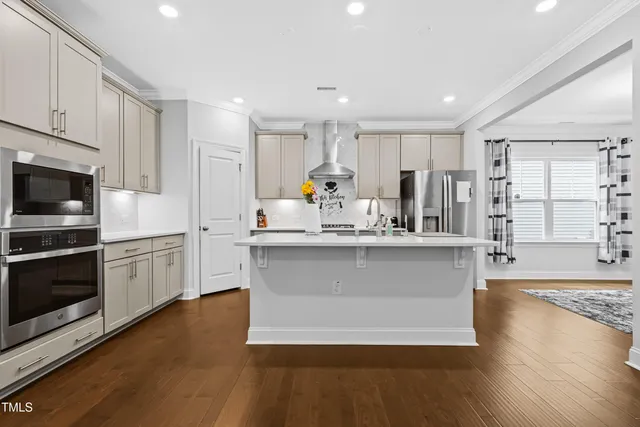 a kitchen with kitchen island white cabinets and stainless steel appliances