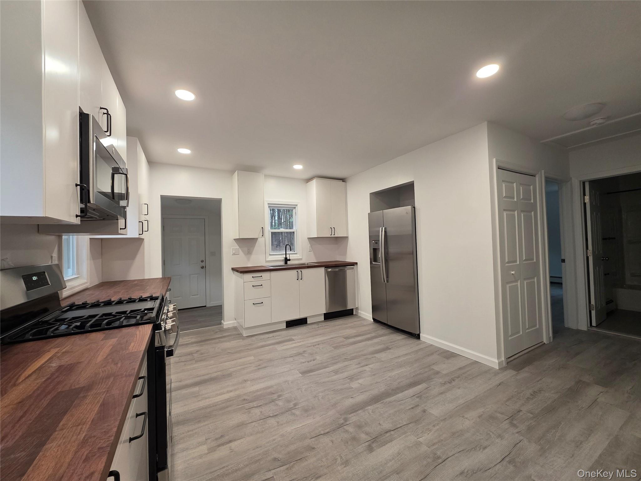 200 Deforest Road Dix Hills, NY 11746 - Photo 3 of 20 a kitchen with stainless steel appliances kitchen island a refrigerator sink and cabinets
