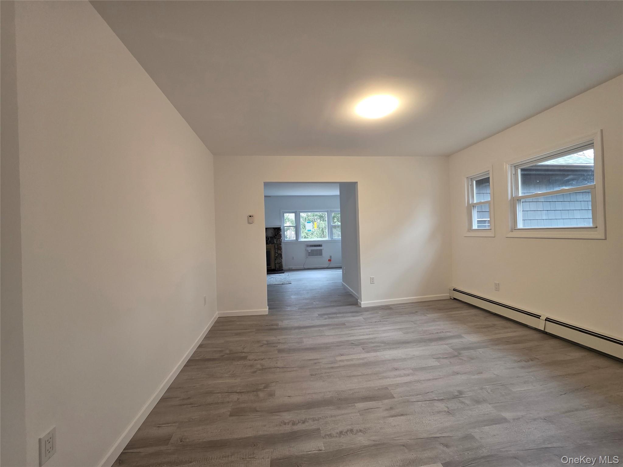 200 Deforest Road Dix Hills, NY 11746 - Photo 5 of 20 a view of an empty room with window and wooden floor