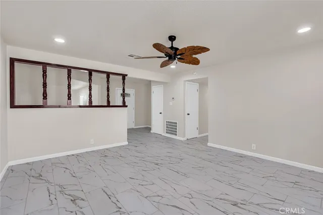 a view of a big room with wooden floor and a chandelier fan in a room