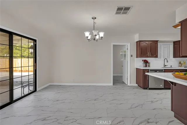a view of a kitchen with stainless steel appliances granite countertop a stove top oven a sink dishwasher and a refrigerator with wooden floor