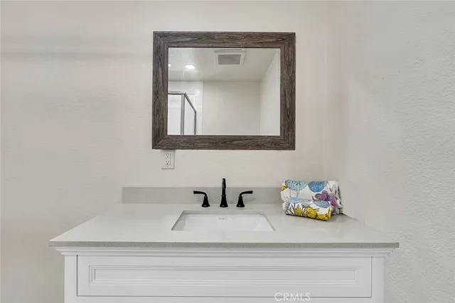 a bathroom with a sink mirror and vanity
