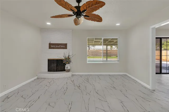 an empty room with windows and fireplace