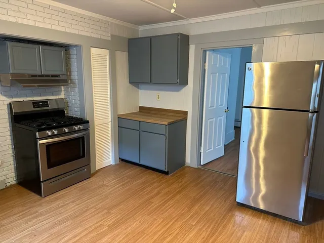 a kitchen with granite countertop a refrigerator and a stove top oven