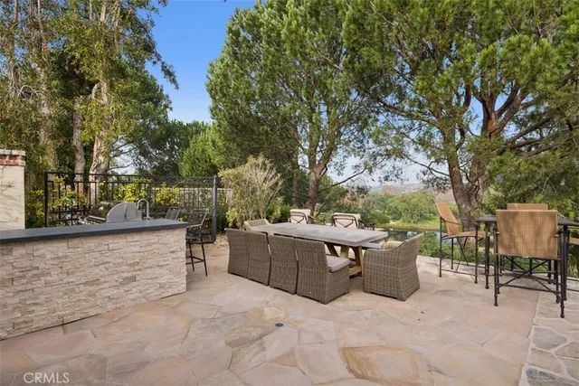 a view of a patio with a bench and some trees