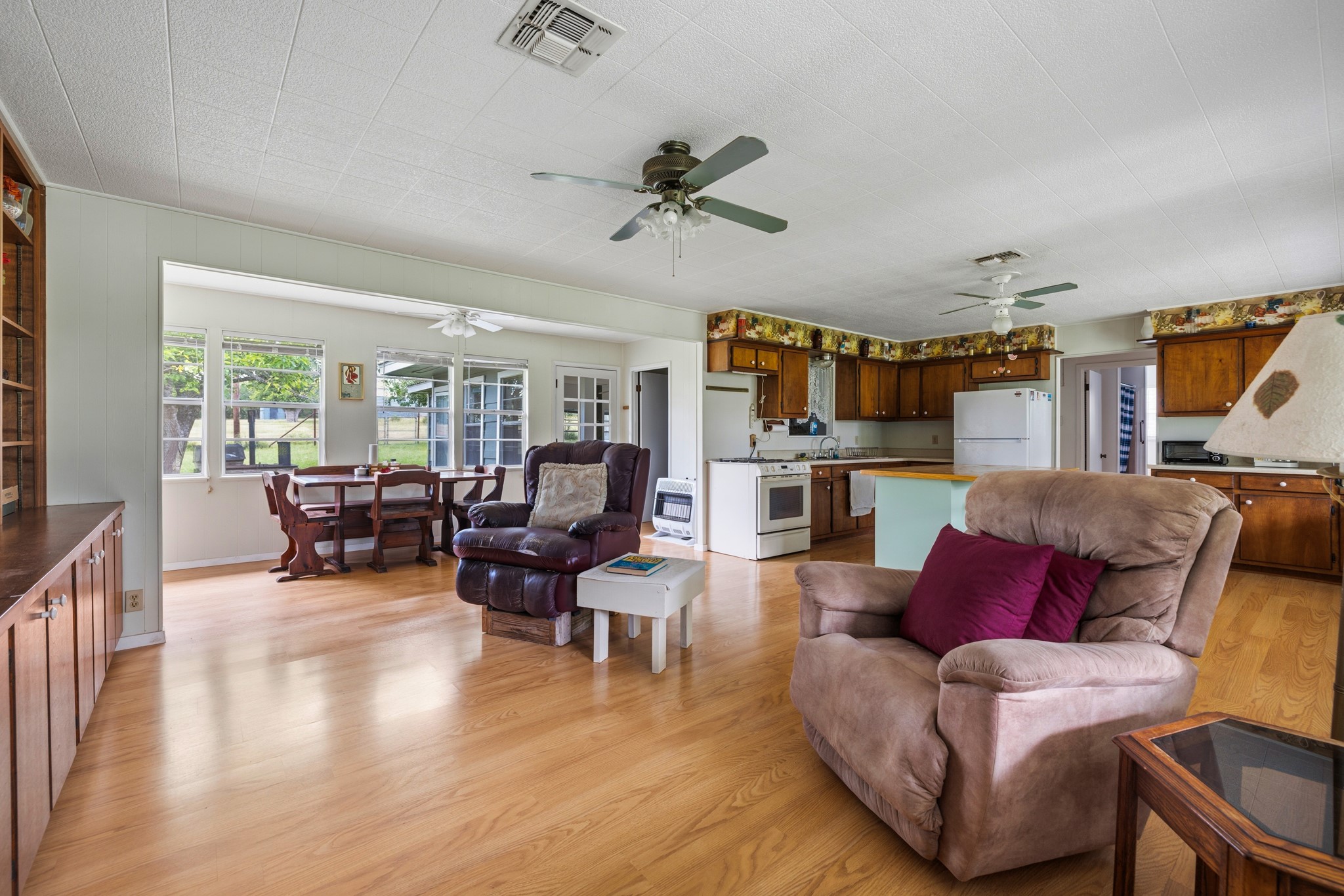 341 River View Road Fredericksburg, TX 78624 - Photo 10 of 40 Smooth wood floors flow seamlessly through this open-concept living area and adjacent kitchen space.