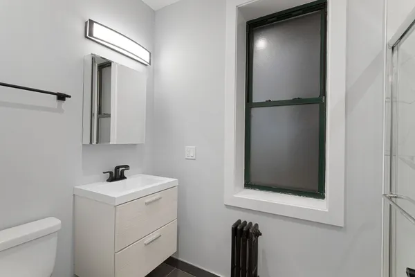 a bathroom with a toilet sink and mirror