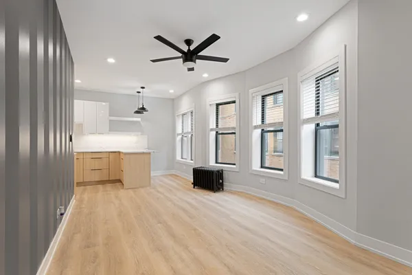 a living room with stainless steel appliances kitchen island granite countertop furniture and a large window