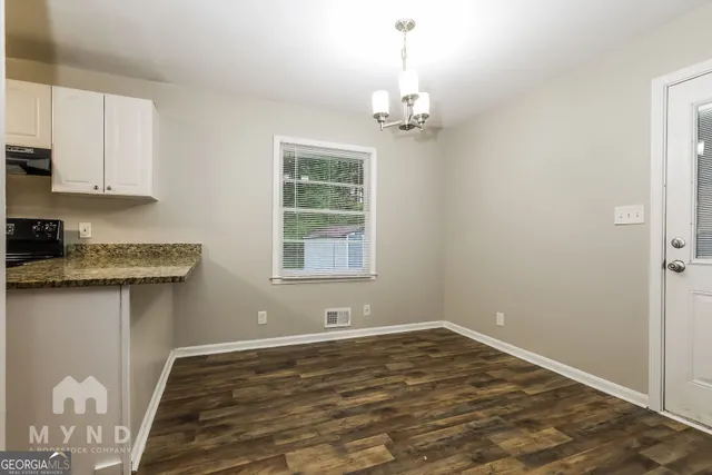 a view of empty room with wooden floor and window