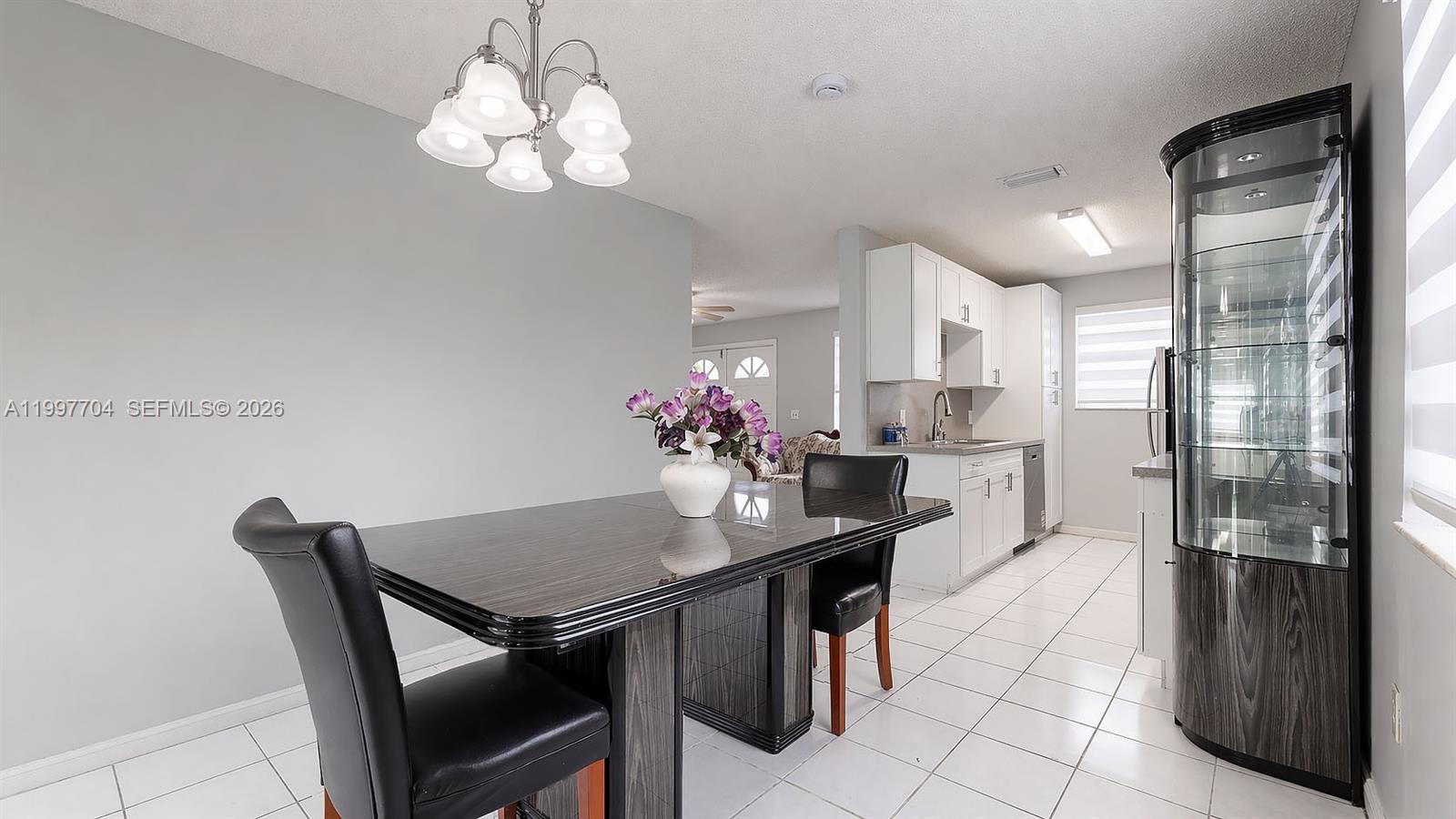 21450 Southwest 109th Court Miami, FL 33170 - Photo 11 of 43 a dining room with stainless steel appliances kitchen island granite countertop a table chairs and a refrigerator