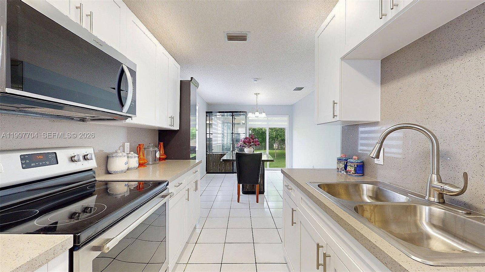 21450 Southwest 109th Court Miami, FL 33170 - Photo 2 of 43 a kitchen with stainless steel appliances a sink a stove and cabinets