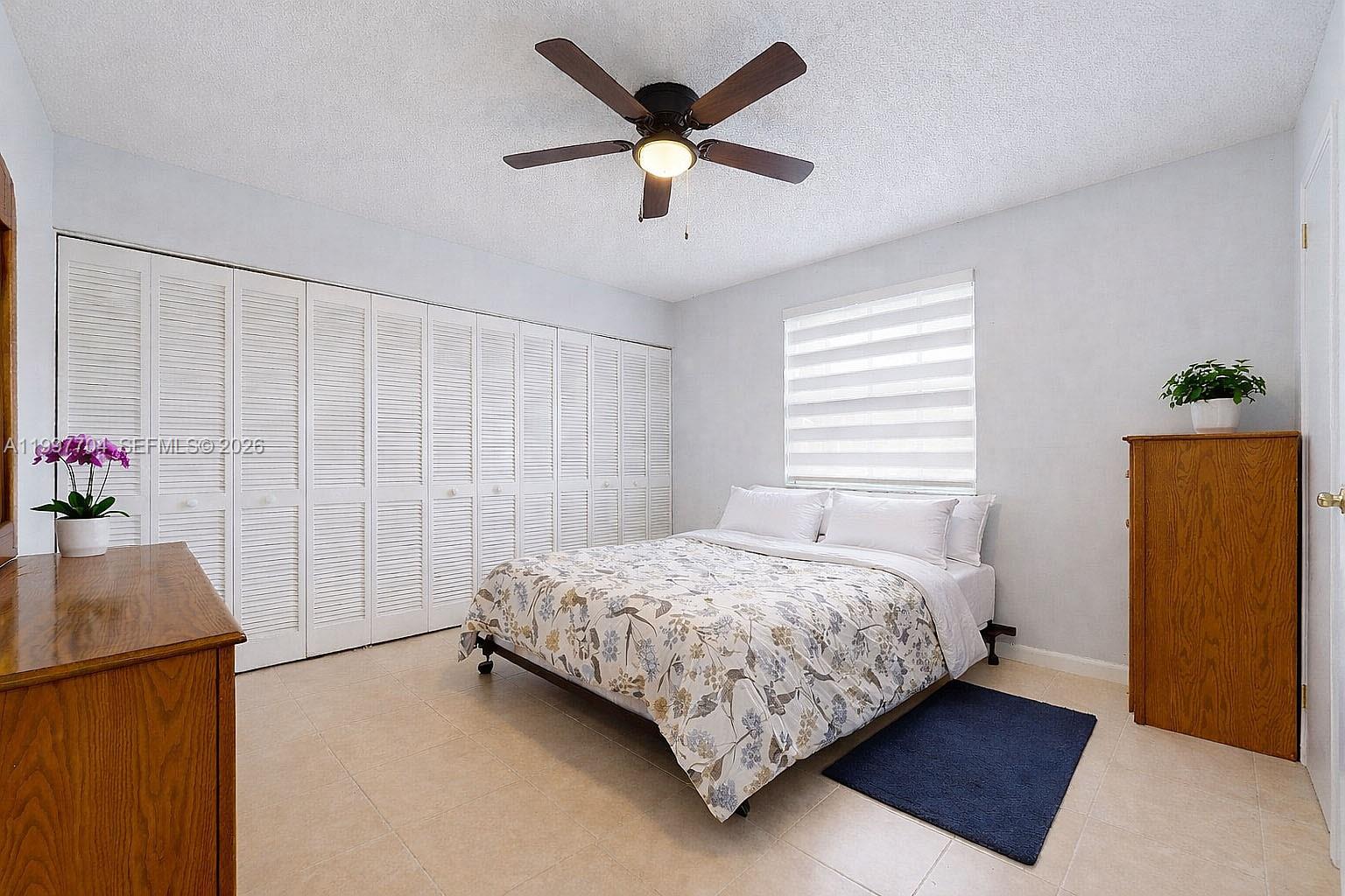 21450 Southwest 109th Court Miami, FL 33170 - Photo 25 of 43 a bedroom with a bed and a chandelier