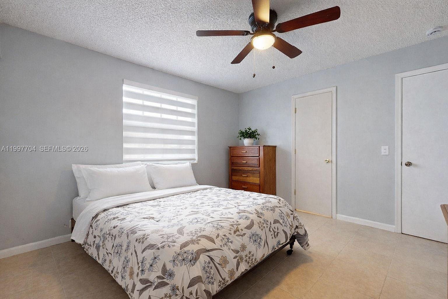 21450 Southwest 109th Court Miami, FL 33170 - Photo 26 of 43 a bedroom with a bed and a chandelier