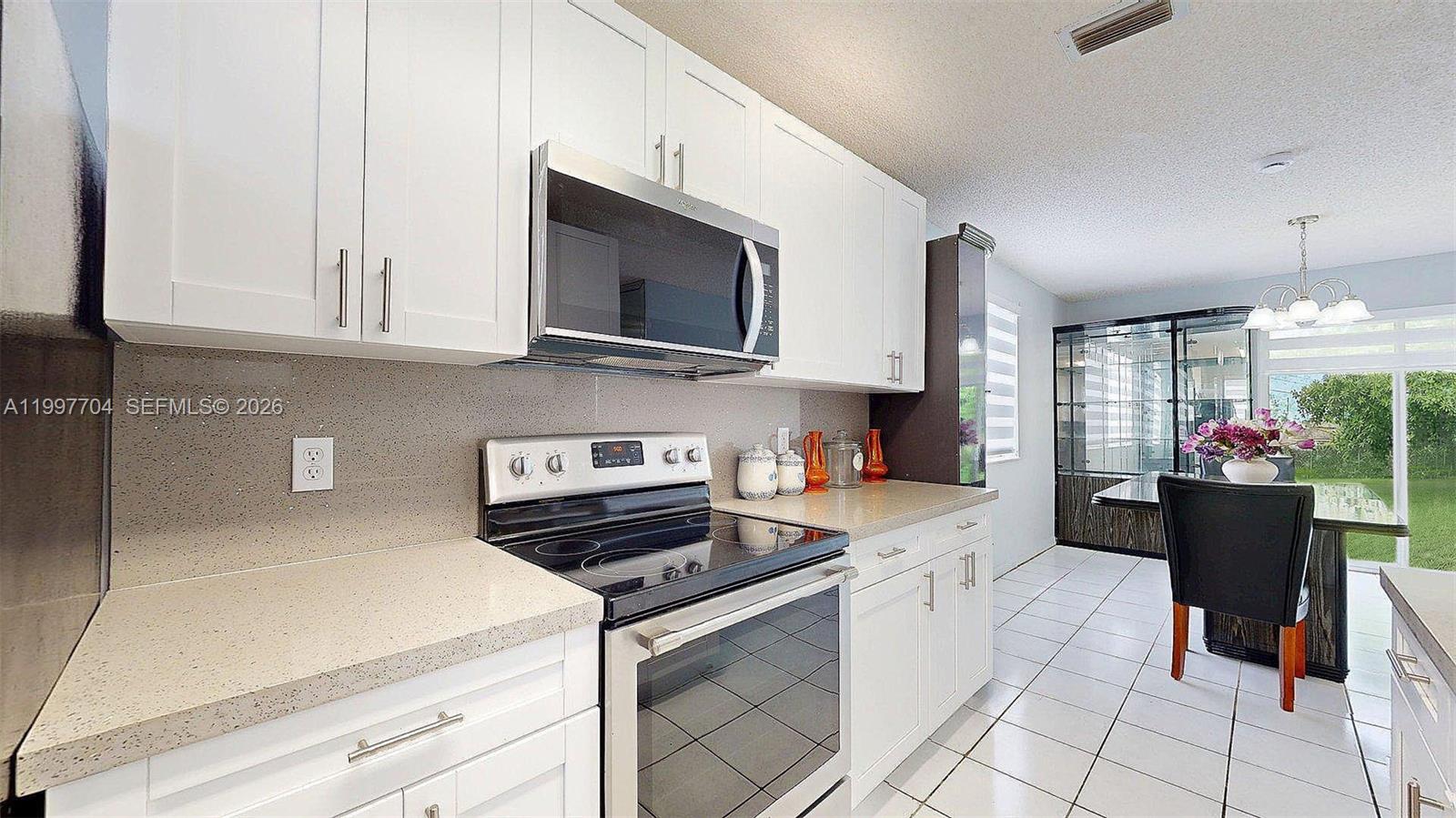21450 Southwest 109th Court Miami, FL 33170 - Photo 3 of 43 a kitchen with stainless steel appliances a stove microwave and cabinets