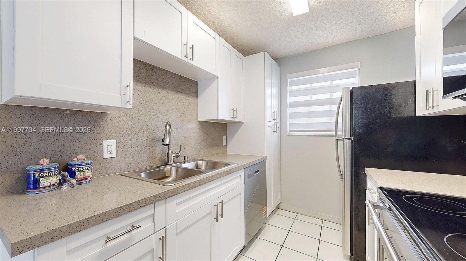 21450 Southwest 109th Court Miami, FL 33170 - Photo 41 of 43 a kitchen with stainless steel appliances granite countertop a sink and a refrigerator
