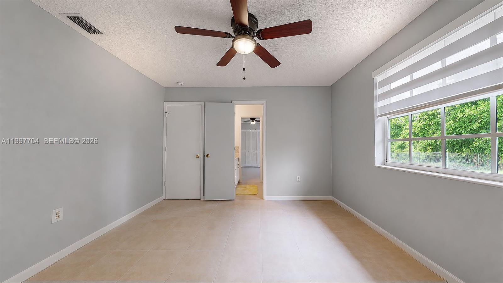 21450 Southwest 109th Court Miami, FL 33170 - Photo 8 of 43 en empty room with windows and ceiling fan