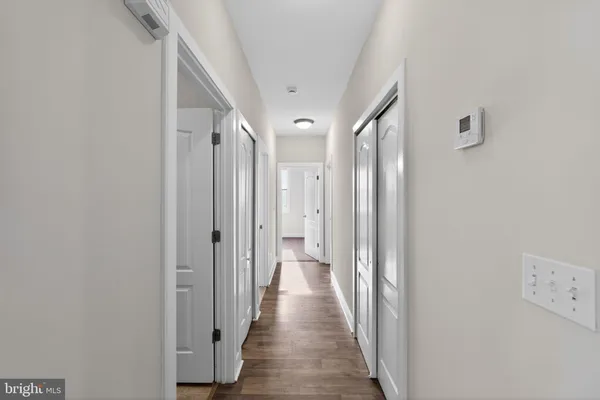 a view of a hallway with wooden floor
