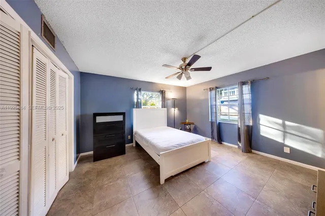 a spacious bedroom with a large bed and a chandelier