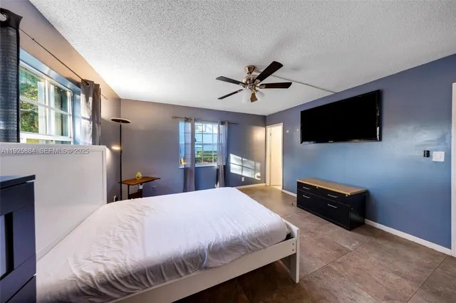 a bed room with a bed a television and a large window