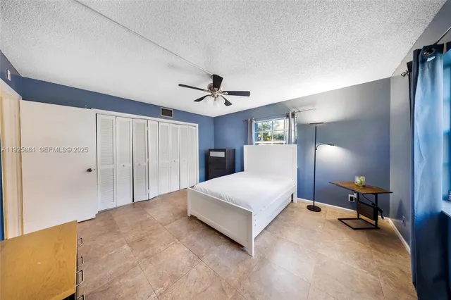 a spacious bedroom with a bed and a chandelier