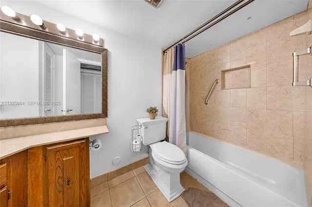 a bathroom with a granite countertop bathtub shower sink vanity and toilet