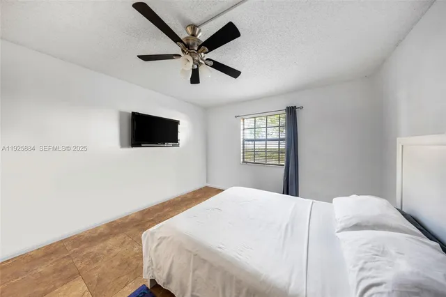 a bedroom with a large bed and a flat screen tv
