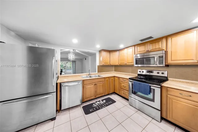a kitchen with stainless steel appliances granite countertop a refrigerator sink and stove
