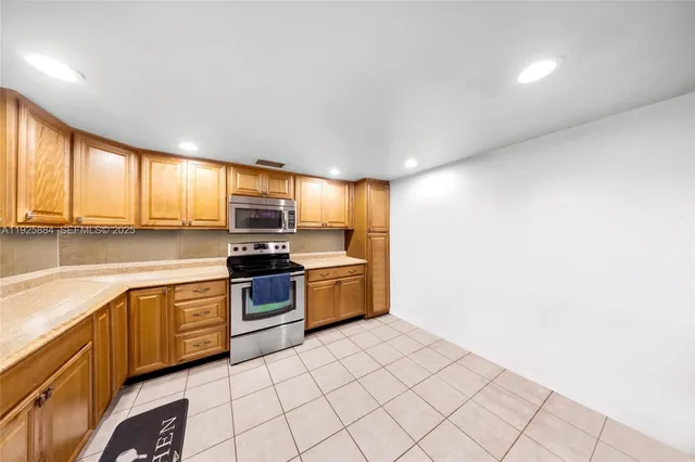 a kitchen with stainless steel appliances granite countertop a stove a sink and a microwave