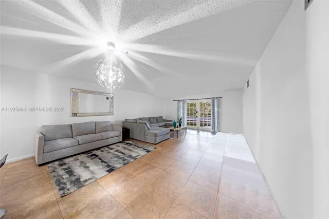 a living room with furniture and a chandelier