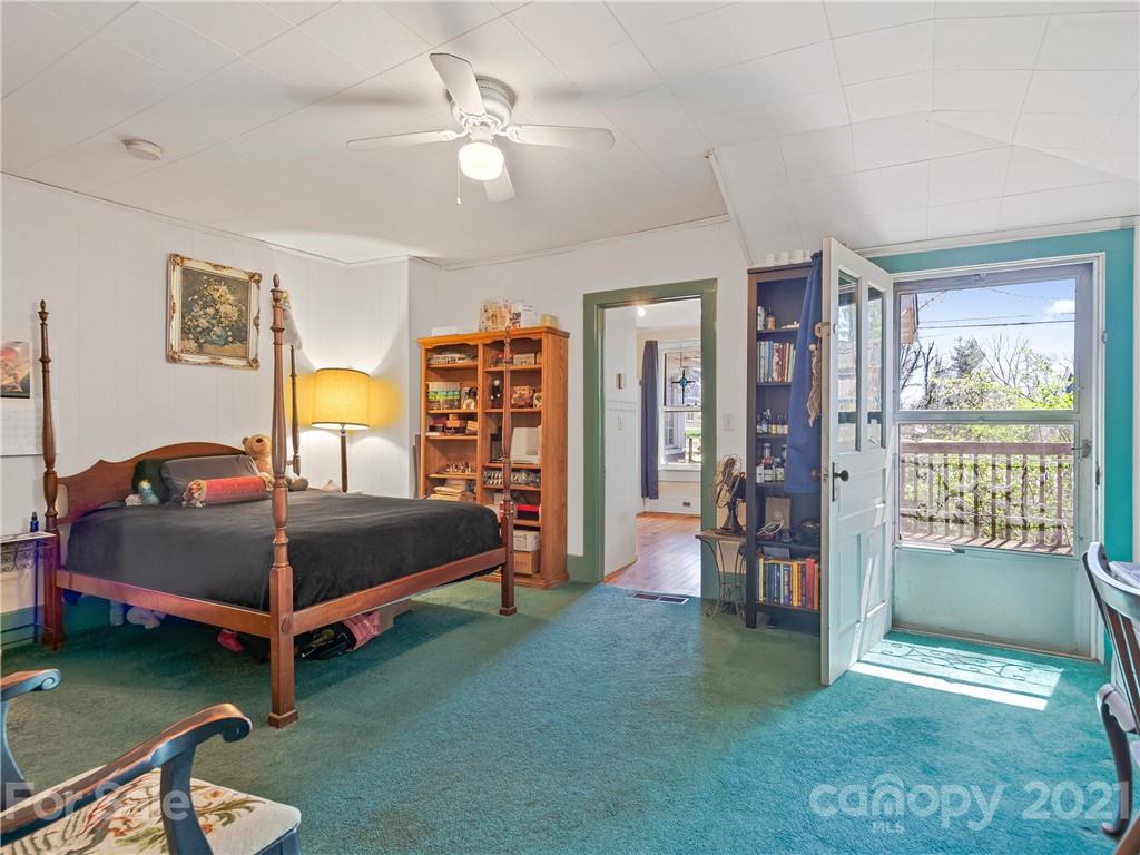 604 Fairview Road Asheville, NC 28803 - Photo 7 of 18 a bedroom with a bed and a chandelier