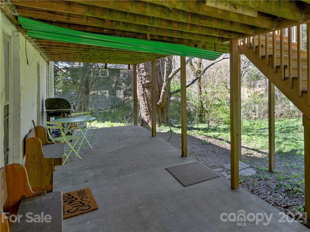 604 Fairview Road Asheville, NC 28803 - Photo 10 of 18 a view of a patio with table and chairs under an umbrella