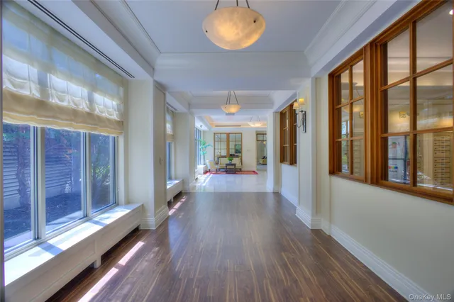 a view of a hallway with wooden floor and windows