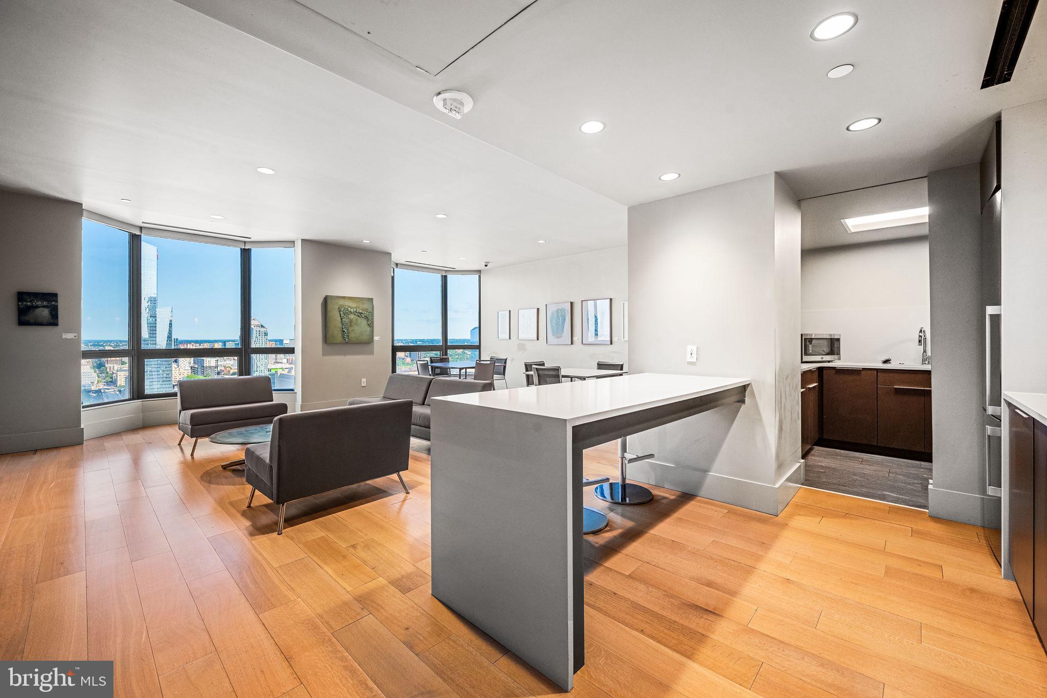 2020 Walnut Street, Unit 19LM Philadelphia, PA 19103 - Photo 48 of 60 a large white kitchen with kitchen island a sink a counter space and a center island