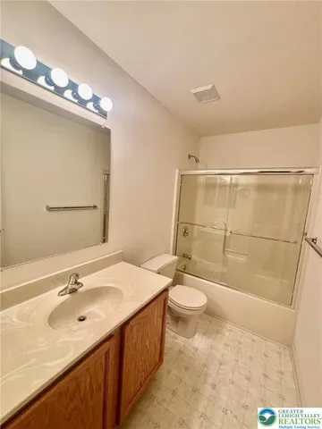 a bathroom with a sink a toilet a mirror and shower