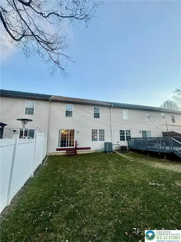 a view of a couches with table and chairs in front of house