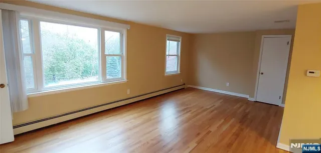 a view of a room with wooden floor and windows