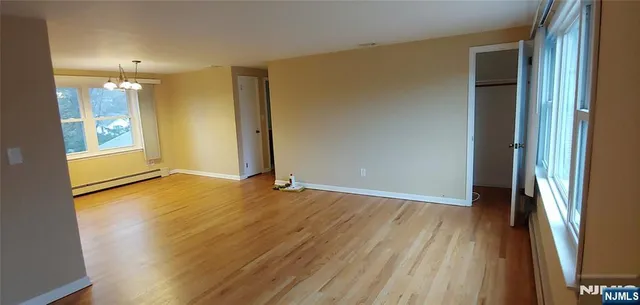 an empty room with wooden floor and a window