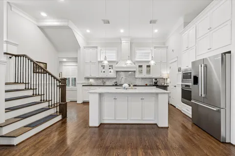 a kitchen with kitchen island white cabinets and stainless steel appliances