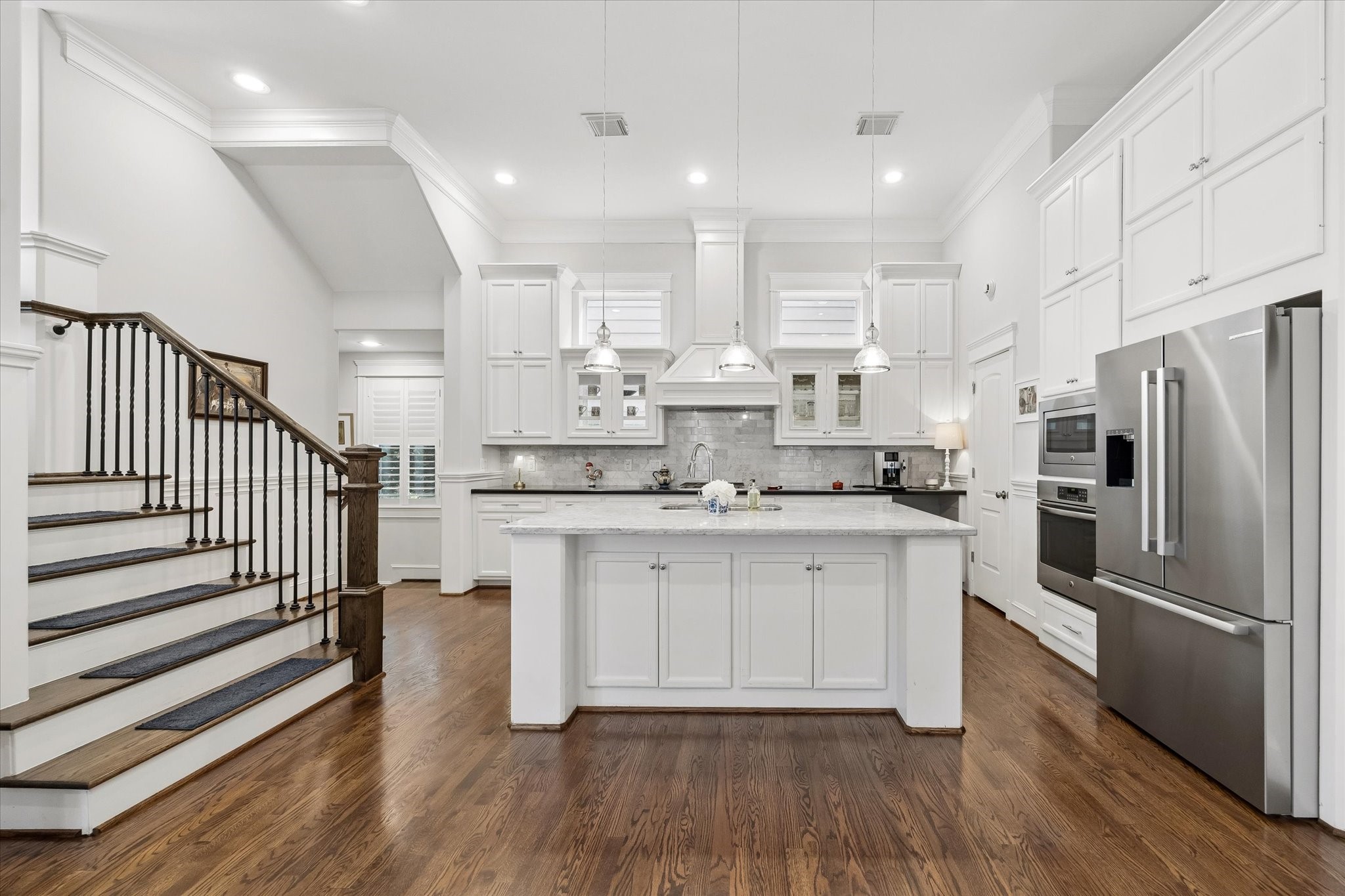 609 Rutland Street, Unit A Houston, TX 77007 - Photo 12 of 30 a kitchen with kitchen island white cabinets and stainless steel appliances