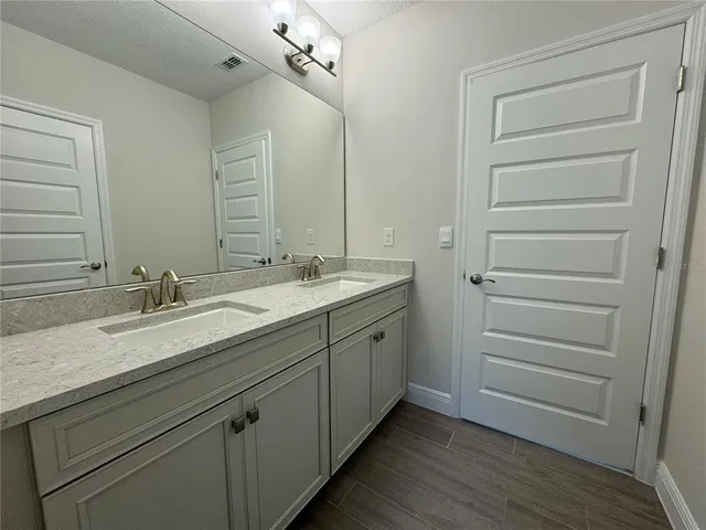 a bathroom with a double vanity sink and a mirror