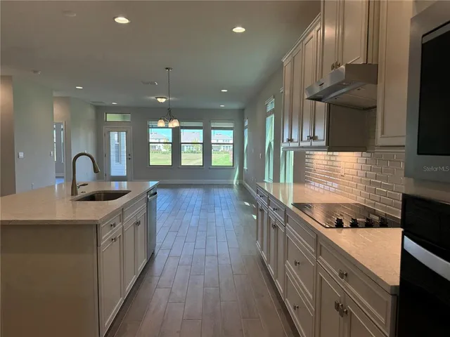 a kitchen with kitchen island granite countertop a sink stainless steel appliances and cabinets